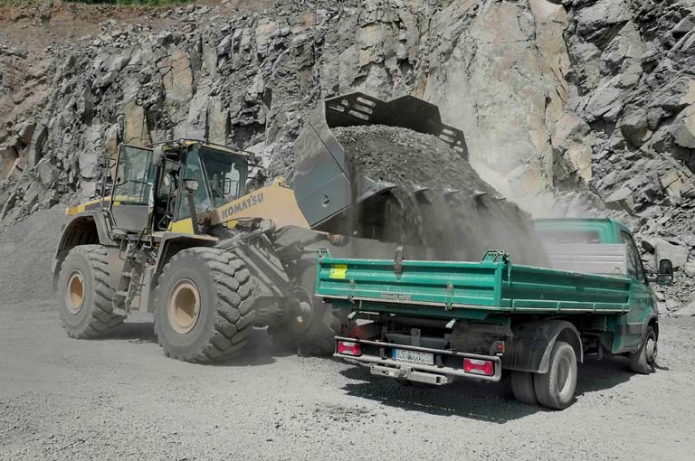 Bagger belädt MEILLER Dreiseitenkipper